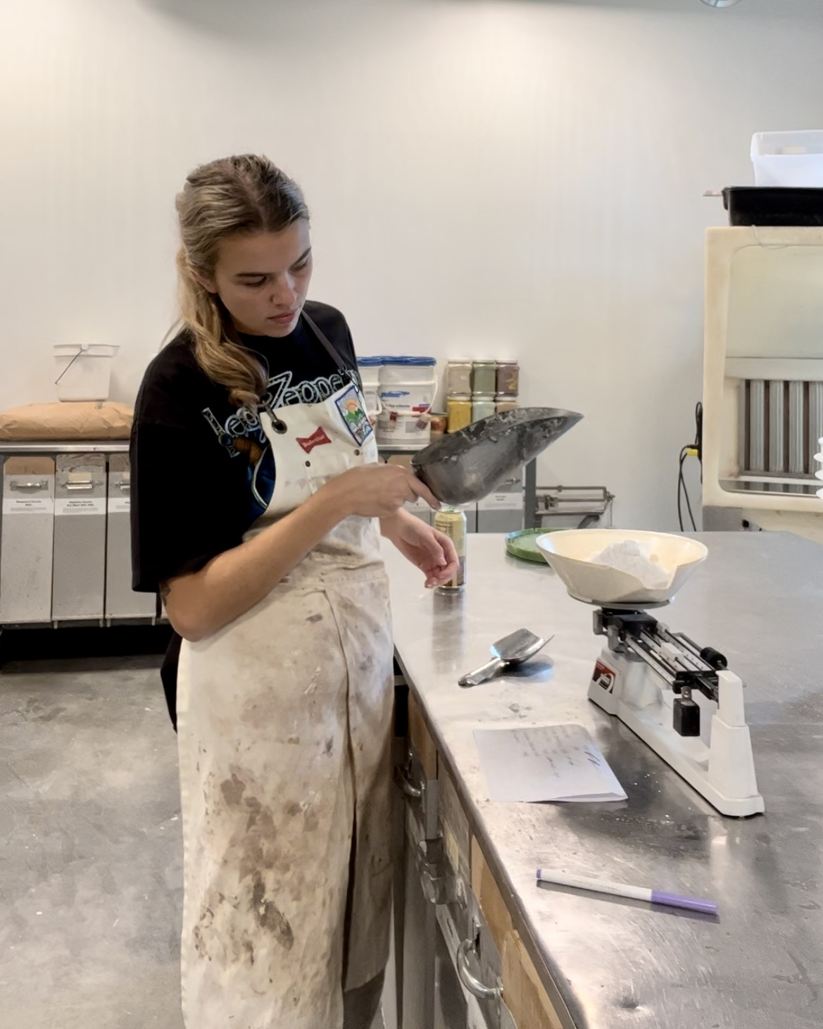 female artist, Ari Mullins in ceramic studio mixing ceramic glazes